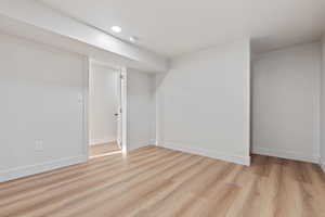 Finished below grade area with recessed lighting, baseboards, and light wood finished floors