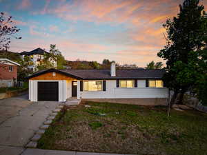 Ranch-style home with cooling unit, an attached garage, concrete driveway, and a chimney