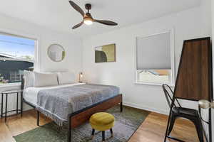 Bedroom with a ceiling fan, baseboards, and wood finished floors