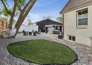 View of yard featuring fence private yard, a hot tub, an outdoor fire pit, and a wrap around deck to side entry door.
