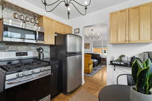 Kitchen featuring newer cabinetry, stainless steel appliances, a drink bar, chandelier