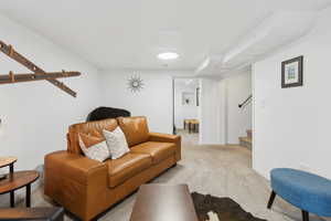 Basement Living area featuring baseboards, carpet, and stairway