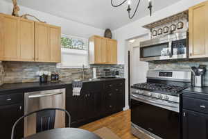 Kitchen featuring a sink, newer cabinetry, dark countertops, and stainless steel appliances