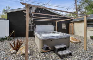 View back yard with a hot tub, and fence