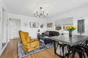 Living area with an inviting chandelier, baseboards, and hardwood flooring, pantry and hall closet