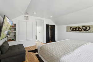 Bedroom with 2 closets, recessed lighting, wood finished floors, and lofted ceiling