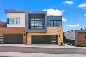 Contemporary home featuring a garage and stone siding