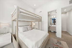 Carpeted bedroom with recessed lighting, visible vents, and ensuite bathroom