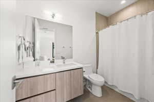Full bath with vanity, tile patterned floors, toilet, and a shower with shower curtain