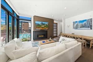 Living area featuring recessed lighting, a glass covered fireplace, and wood finished floors