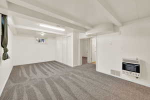 Basement family room with fresh paint and new carpet- wall heater.