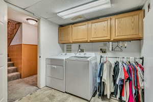 Laundry area with cabinet space, wainscoting, and washer and dryer
