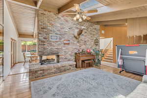Living room featuring wood finished floors, wood ceiling, ceiling fan, and beam ceiling