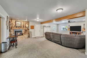 Carpeted living area with a ceiling fan, baseboards, and beam ceiling