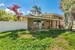 Rear view of house with brick siding and fence