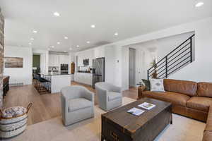 Living area featuring visible vents, stairs, baseboards, light wood-style floors, and recessed lighting