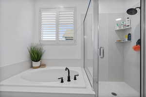 Bathroom featuring a stall shower and a bath
