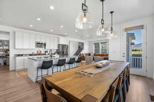 Dining area featuring recessed lighting, light wood finished floors, and stairway
