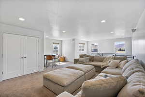 Living area with recessed lighting, a textured ceiling, and light colored carpet