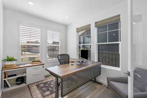 Office with light wood-style floors and recessed lighting