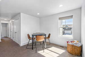 Carpeted dining area with baseboards, recessed lighting, and visible vents