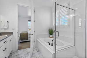 Full bath with vanity, plenty of natural light, a shower stall, and a garden tub