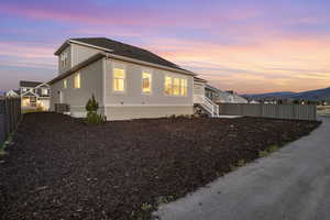 Property exterior at dusk with fence and central AC unit