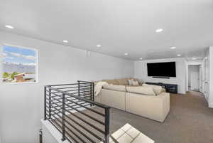 Living area with carpet flooring, recessed lighting, and visible vents