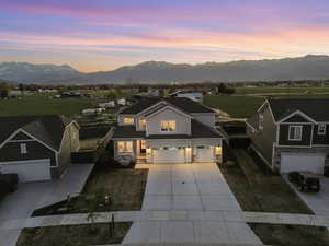 Traditional-style home featuring an attached garage, a mountain view, stone siding, and concrete driveway
