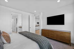 Bedroom with recessed lighting, connected bathroom, and light colored carpet
