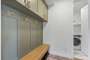 Mudroom featuring baseboards, light wood finished floors, and washer / clothes dryer