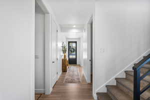 Hall featuring stairs, recessed lighting, baseboards, and wood finished floors