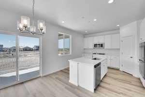 Kitchen with an inviting chandelier, stainless steel appliances, recessed lighting, and a sink