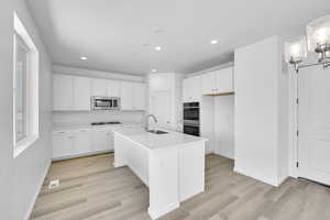 Kitchen featuring white cabinets, a sink, stainless steel appliances, recessed lighting, and visible vents