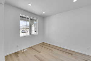 Empty room featuring visible vents, recessed lighting, light wood finished floors, and baseboards