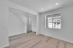 Empty room with baseboards, recessed lighting, wood finished floors, and visible vents