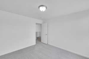 Spare room with baseboards and carpet flooring