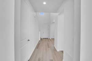Hall featuring recessed lighting, baseboards, visible vents, and light wood-style floors