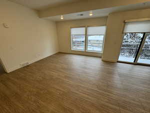Empty room with visible vents, baseboards, and wood finished floors