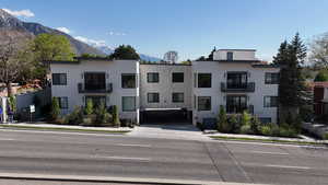 View of front of home with a mountain view, stone siding, and a balcony