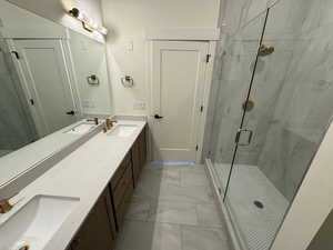 Full bath with a sink, a stall shower, and marble finish floor
