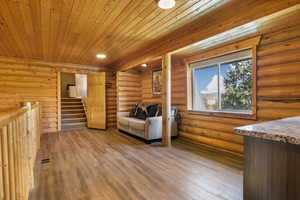 Sitting room featuring recessed lighting, wooden ceiling, light wood-type flooring, rustic walls, and visible vents