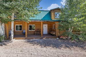 View of front facade with a porch and metal roof