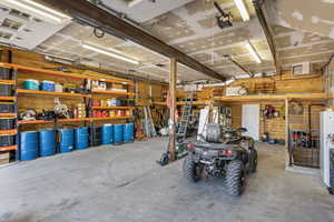 Garage with a workshop area, a garage door opener, and visible vents