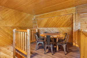Dining room with wood walls, wood ceiling, and wood finished floors
