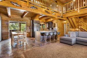 Kitchen featuring log walls, wood ceiling, a wealth of natural light, and beamed ceiling