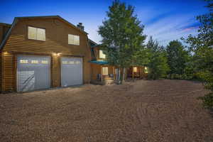 Exterior space featuring driveway, a chimney, and a gambrel roof