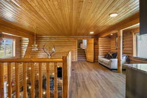 Interior space featuring stairway, wooden ceiling, light wood finished floors, log walls, and recessed lighting