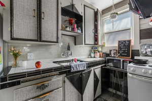 Kitchen featuring gas range gas stove, decorative backsplash, stainless steel microwave, and tile countertops