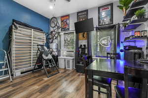 Home office with a ceiling fan, wood finished floors, and cooling unit